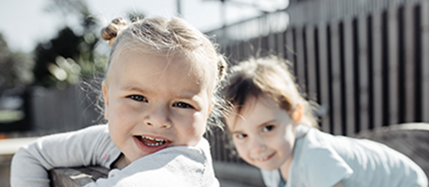Two children smiling together outdoors