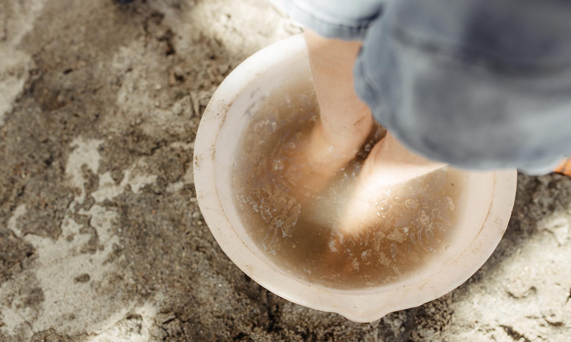A child's foot in a bowl of water, exploring by touch