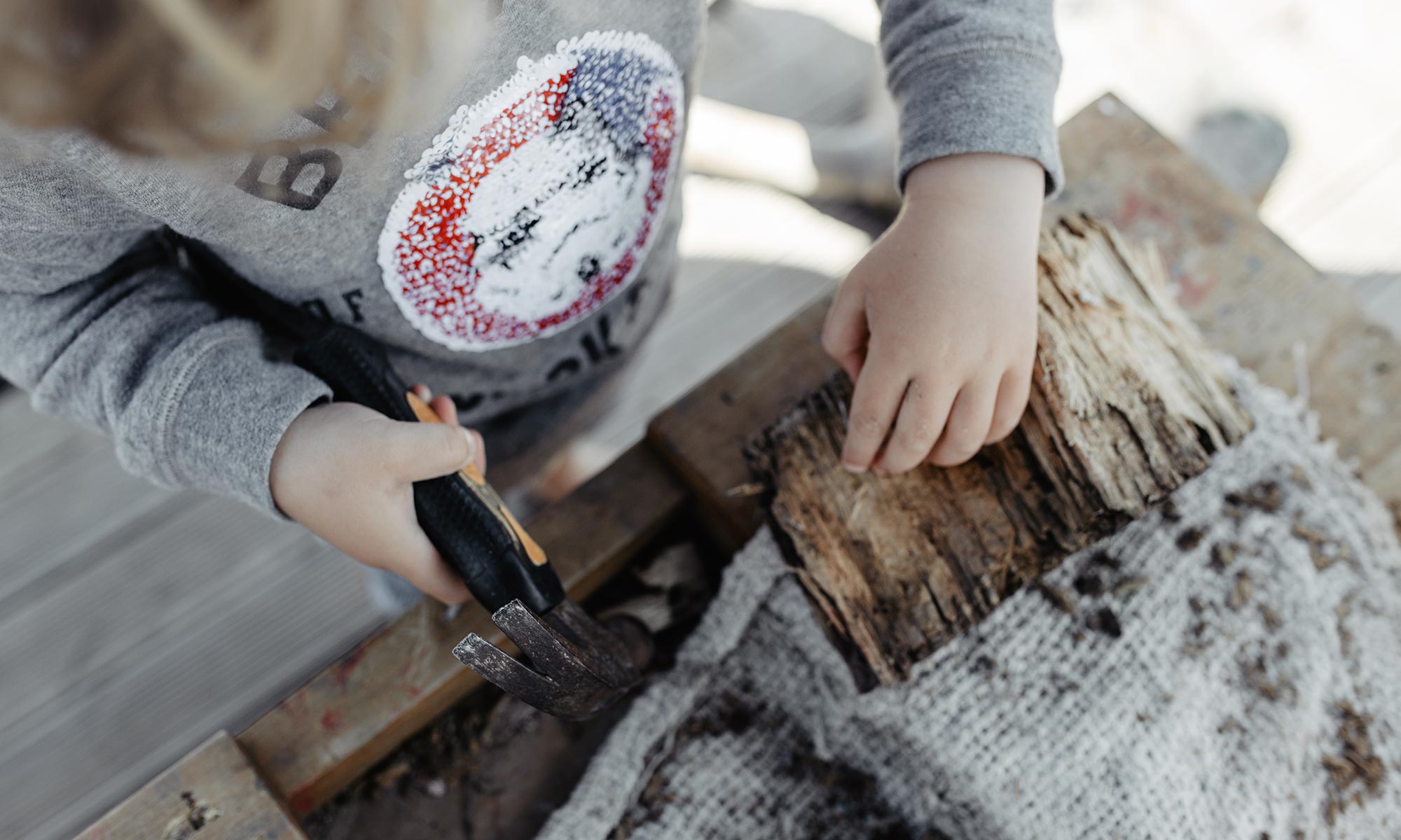 A child using a hammer and tools